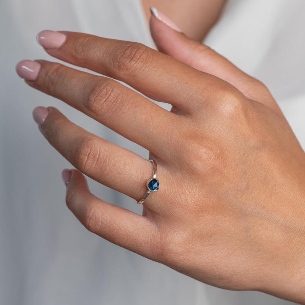 Model wears London Bliue Topaz Hammered Sterling Silver Ring , with a white blouse and frenchtip manicured nails.