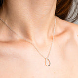 Sterling Silver Necklace with a Pear shaped pendent. Worn on a model with side profile.