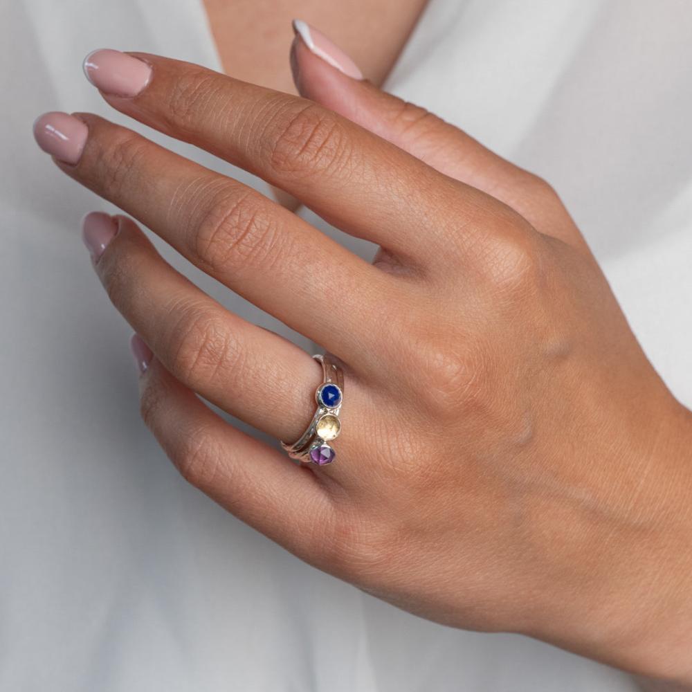 Model wears Cosmos Hammered Sterling Silver Ring Stacking set, with a white blouse and frenchtip manicured nails.