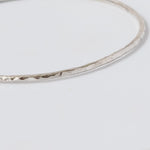 Handmade Hammered Sterling Silver Bangle close up on white background 