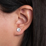 Sterling Silver Round shaped Hammered Textured Earrings worn on models ear lobe