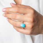 Turquoise Gemstone Sterling Silver Statement Ring worn on models hand.  Model wears a white shirt.