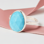 Turquoise Gemstone Sterling Silver Statement Ring with a pink ribbon background